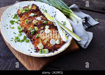 Gebratene Kartoffelpfannkuchen auf dem alten Holzhintergrund Stockfoto