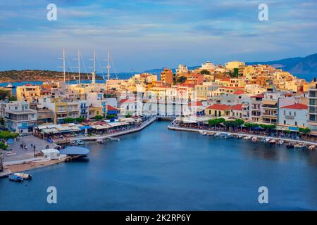 Schöne Stadt Agios Nikolaos am See Voulismeni bei Sonnenuntergang. Insel Kreta, Griechenland Stockfoto