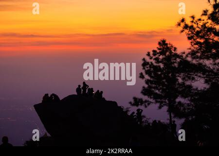 Reisende Silhouetten stehen auf Felsen mit Licht Sonnenaufgang. Stockfoto