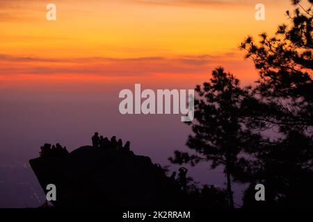 Reisende Silhouetten stehen auf Felsen mit Licht Sonnenaufgang. Stockfoto