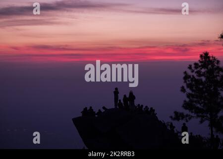 Reisende Silhouetten stehen auf Felsen mit Licht Sonnenaufgang. Stockfoto