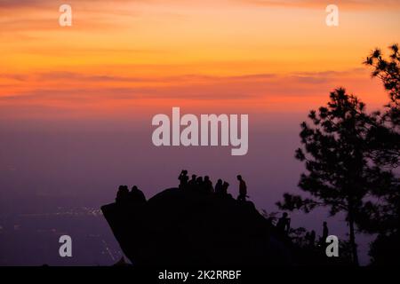 Reisende Silhouetten stehen auf Felsen mit Licht Sonnenaufgang. Stockfoto