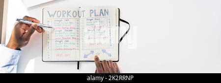 Person, die Kenntnis von Workout Plan auf Notebook Stockfoto