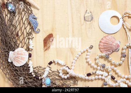 Fischernetze und Meeresmuscheln auf Holzhintergrund Stockfoto