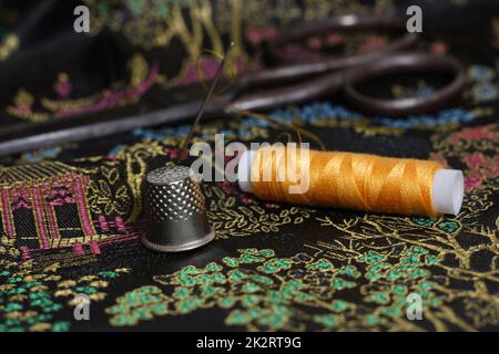 Gelbes Faden und Kaugummi auf klassischer chinesischer schwarzer Seide Stockfoto