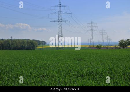 Mehrere Hochspannungsmasten gegen einen blauen Himmel Stockfoto