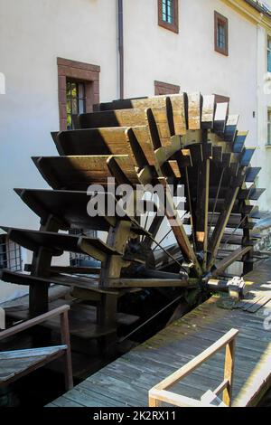 Ein altes hölzernes Wasserrad einer Mühle an einem Bach. Stockfoto