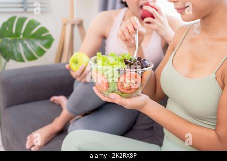 Zwei wundervolle Frauen, die zu Hause ein gesundes Frühstück haben, nach dem Yoga-Training mit Glück Stockfoto