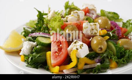 Griechischer Salat. Frischer Gemüsesalat mit Tomaten, Zwiebeln, Gurken, Paprika, Oliven, Olivenöl, Salat, rote Zwiebeln und Feta-Käse. Stockfoto