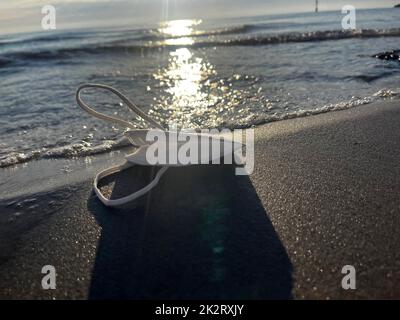 Urlaub in Covid-19-Zeiten mit Maske am Strand Stockfoto