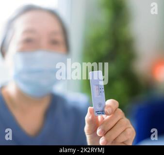 Ältere Frau mit Antigen-Selbsttestkarte mit negativem Ergebnis für Covid-19 Stockfoto