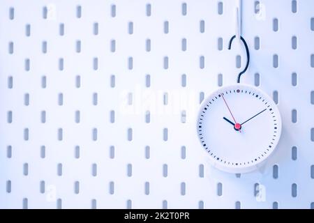 Closeup blaue Wanduhr auf blauem Hintergrund Stockfoto