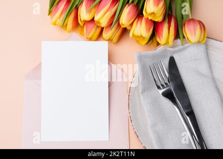 Nachahmung für eine Einladung oder ein Menü mit Glückwunschkarten. Leere Karte in einem Umschlag mit eleganter Tischeinstellung. Stockfoto