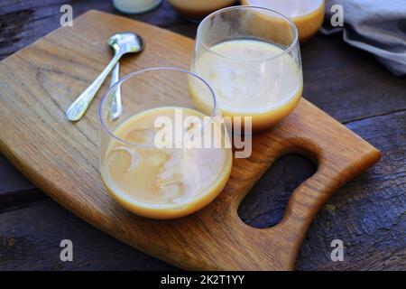 Eiskaffee mit Milchgläsern auf rustikalem Holztisch, selektiver Fokus Stockfoto