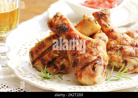 Gegrillte Hähnchenschenkel mit Rosmarin auf Tisch Stockfoto