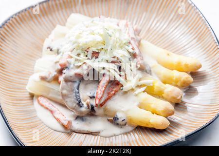 Weißer Aparagus mit Pilzsauce und Schinken, serviert mit Blauschimmelkäse Stockfoto