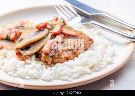 Schweinefilet mit Pilzsauce und Schinken mit weißem Reis serviert Stockfoto