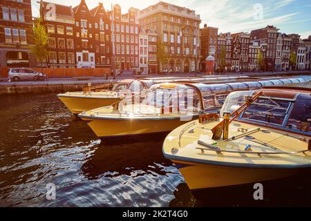 Amsterdamer Touristenboote auf dem Kanal Stockfoto