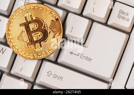 Bitcoin-Token-Münze auf einer Computertastatur Stockfoto