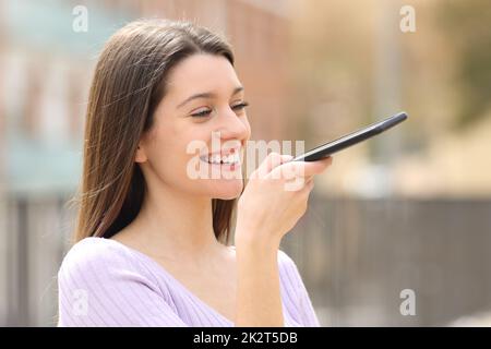 Glückliche Teenager diktieren Text per Spracherkennung Stockfoto