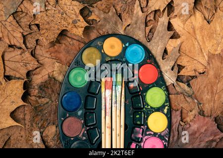 Aquarellfarben, Pinsel und Herbstblätter Stockfoto