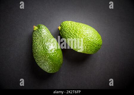 Zwei Avocados isoliert auf schwarzem Hintergrund Stockfoto