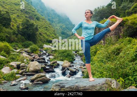 Frau Yoga Asana im Freien an Wasserfall Stockfoto