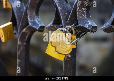 Nahaufnahme des herzförmigen Liebesschlosses, das an einem Brückenzaun hängt Stockfoto