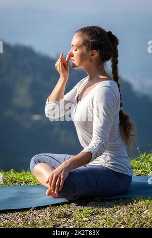 Frau Praktiken Pranayama in Lotus Pose im freien Stockfoto