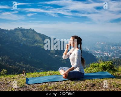 Frau Praktiken Pranayama in Lotus Pose im freien Stockfoto