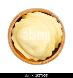 Große gefüllte Teigtaschen, ungekochte, gefüllte Eierpasta in einer Holzschüssel Stockfoto