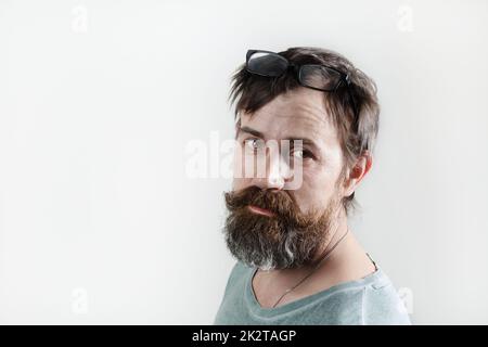 Bärtiger, zotteliger Mann. Studio-Porträt auf einem hellen Hintergrund. Stockfoto