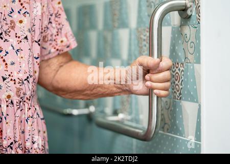 Asiatische ältere oder ältere alte Dame Frau Patienten verwenden Toilette Badezimmer Griff Sicherheit in Krankenpflege-Station, gesund starke medizinische Konzept. Stockfoto