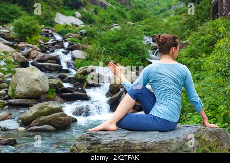 Frau tut Ardha Matsyendrasana Asana im freien Stockfoto