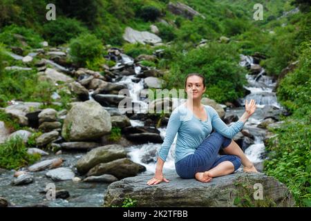 Frau tut Ardha Matsyendrasana Asana im freien Stockfoto