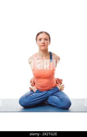 Sportliche Frau, die Ashtanga Vinyasa Yoga asana Baddha Padma macht Stockfoto