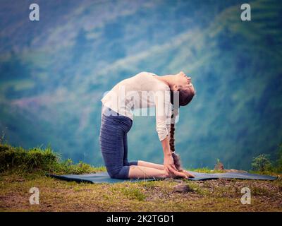 Frau tut Yoga Asana Ustrasana Kamel-Pose im freien Stockfoto