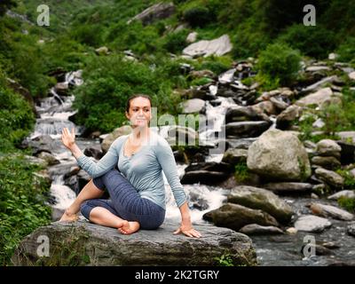 Frau tut Ardha Matsyendrasana Asana im freien Stockfoto