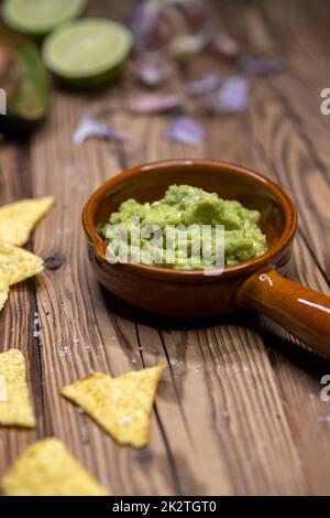 Avocado Dip mit Knoblauch, Chili, Pfeffer und Limettensaft mit Mais Nachos gewürzt Stockfoto