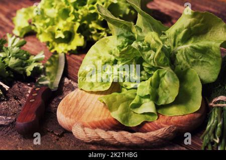 Rohe grüne Bio-Butter Salat bereit, auf Schneidebrett mit Messer hacken Stockfoto