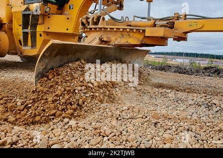 Das Grader-Blatt ebbt den Schutt auf der Baustelle Stockfoto