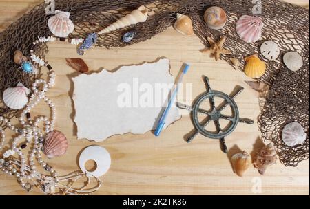 Leeres Papier mit verbrannten Kanten auf Holzhintergrund mit Meeresmuscheln und Fischernetz. Nautisches und Küstenthema Stockfoto