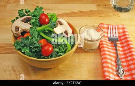 Salat mit Tomaten und Pilze auf einem Tisch mit Gabel Stockfoto