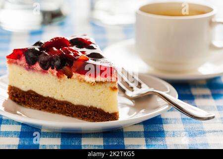 Kuchen auf Teller mit Gabel und Kaffee Tasse Stockfoto