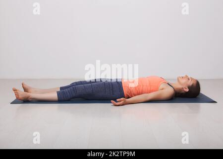 Schön sportlich Fit Yogi Mädchen entspannt sich im Yoga Asana Savasana Stockfoto