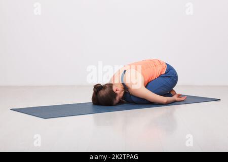 Schön sportlich fit Yogi Mädchen Praktiken Yoga Asana balasana Stockfoto