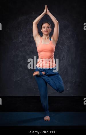 Frau Praktiken Yoga Asana Vrikshasana Baum po Stockfoto