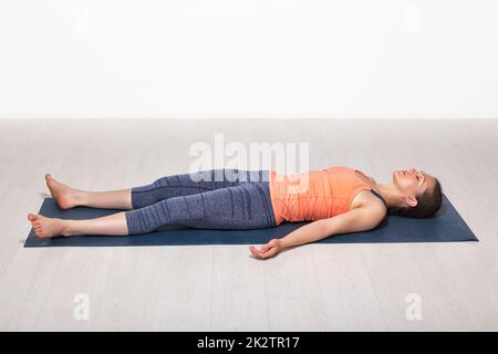 Sportlich Fit Mädchen entspannt sich im Yoga Asana Savasana Stockfoto