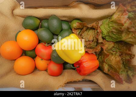 Buntes Gemüse und Obst, die in den Korb gelegt werden Stockfoto