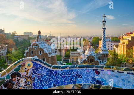 Blick auf die Stadt Barcelona vom Parc Güell. Blick auf das farbenfrohe Mosaikgebäude im Park Güell bei Sonnenaufgang Stockfoto